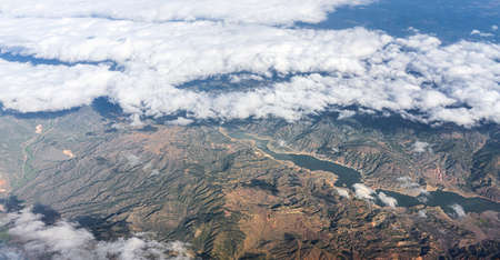 the mountains of Turkey and the clear blue sky with white clouds, a beautiful landscape from above, a view from an airplaneの写真素材
