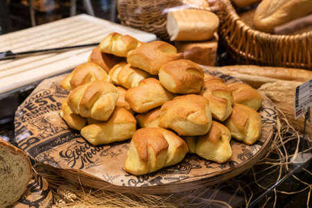 fresh sweet golden shaped buns on a tray in the bakery on the window. fresh pastries, small businessの写真素材