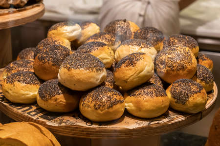 fresh buns with poppy seeds on a wooden tray. bakery in turkey, small business, bread bakingの写真素材