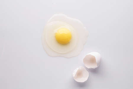 broken egg and shell on a white background, flat layの写真素材