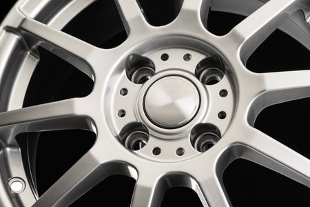 Sports aluminum wheel cast disc with thin spokes close-up on black background, lightweight designの写真素材