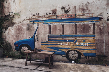 Thailand, Phang Nga, Takua Pa March 2, 2023 . Drawing of a blue traditional Thai bus on an old shabby wall. Art object coffee shop interiorのeditorial素材