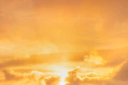 A stunning golden sunset glows over the clouds, creating a serene and enchanting atmosphereの写真素材