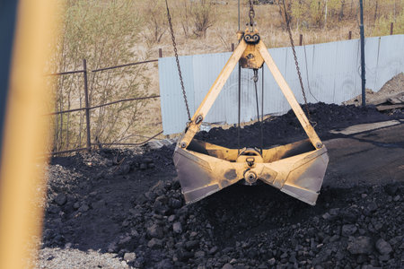 Coal loading. Top view from the bridge of the crane. Coal bucket being loaded and unloaded by...