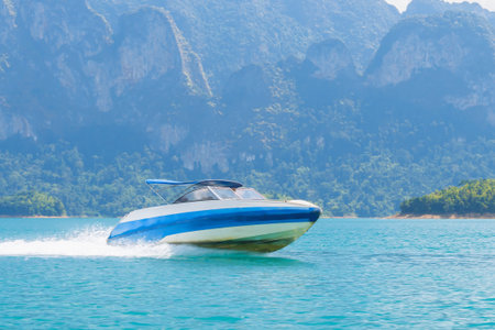 Emerald Escape: Speedboat Slicing Through Cheow Lan Lake Crystal Waters with Khao Sok Cliffs as...