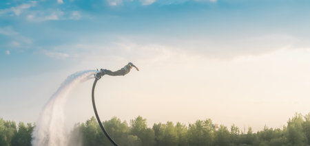 A person on a flyboard performs an aerial stunt over the water. Extreme sports.