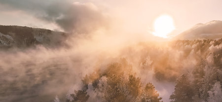 Sun rises over a snowy forest in Krasnoyarsk, Siberia. Frost-covered trees reflect the light of the...