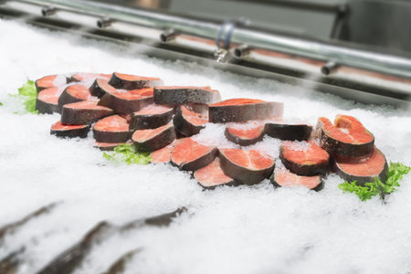 fresh sliced fillet of red salmon steaks on ice, cooled by steam on a showcase in the fish department of a modern supermarket close-up. Red fish is good for your health. High qualityの写真素材
