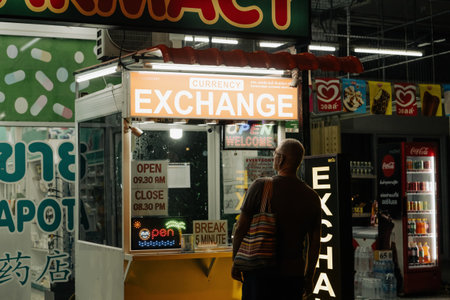 Khao Lak, Thailand, 24 11 2025: Small business in Thai resorts - a tourist looks at the dollar-to-baht exchange rate and wants to exchange money near a typical Thai street currency exchange officeのeditorial素材