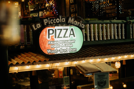 Khao Lak, Thailand, 24 11 2025: Italian pizzeria restaurant in Thailand. A glowing sign with the inscription Pizza on a tourist night street. High quality photoのeditorial素材