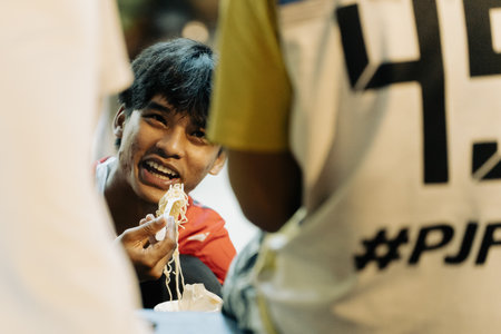 Khao Lak, Thailand, 24 11 2025: Candid Moment of Thai Youth Enjoying Street Food at Night Market. High quality photoのeditorial素材
