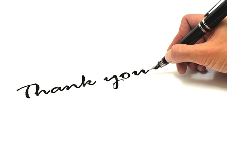 Hand writing thank you over whiteの写真素材