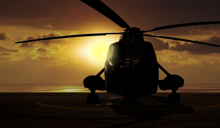 Military helicopter on carrier ship at sunsetの写真素材