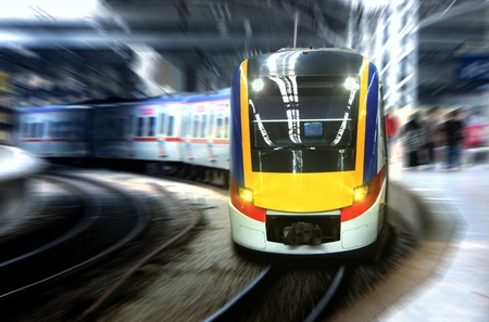 Fast moving train leaving station platform with motion blurの写真素材