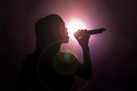 Women singing under spotlightの写真素材