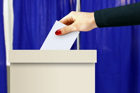 Ballot box with women hand casting a voteの写真素材