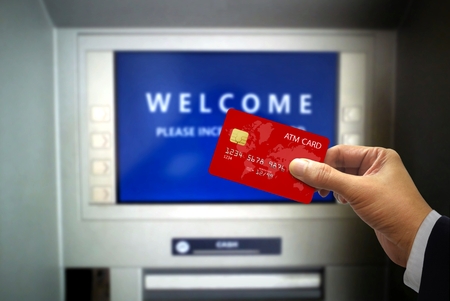 Hand Holding ATM Card at ATM machinesの写真素材
