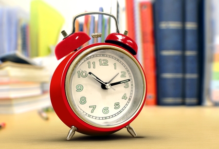 Red alarm clock on study desk