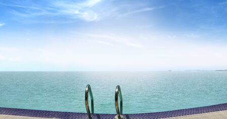 Infinity swimming pool facing sea at sunriseの写真素材