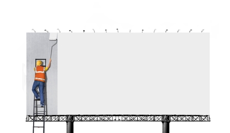 Man on ladder painting on billboardの写真素材
