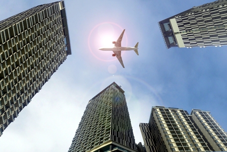 Airplane flying above office buildingsの写真素材