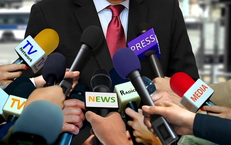 Media and press interview with group of journalists surrounding VIPの写真素材