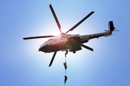 Military commando helicopter drops under bright daylightの写真素材
