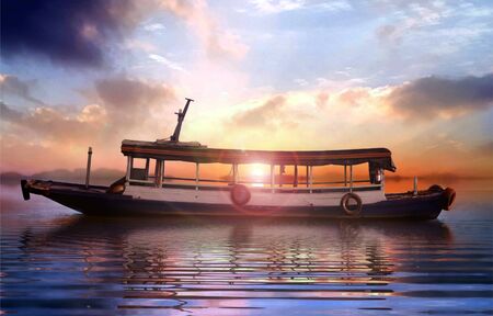 Boat at sea during sunset under cloudy skyの写真素材