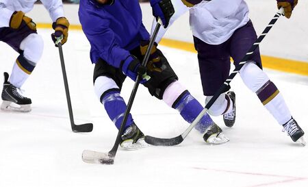Ice hockey player dribbling puck on rinkの写真素材