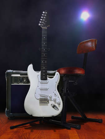 Guitar on stage with amplifier under bright spotlightの写真素材