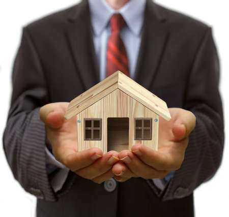 Businessman holding miniature house in his palm. property loan conceptの写真素材