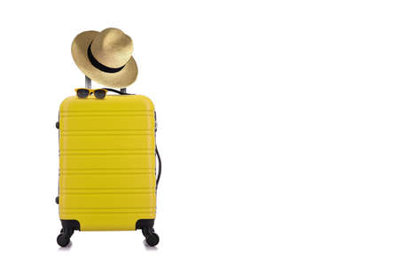 Travelling concept with yellow luggage with hat and yellow sun glasses isolated on white backgroundの写真素材