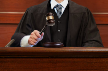Male judge striking the gavel after giving verdict in the courtroomの写真素材