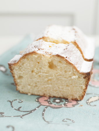 Homemade powedered cake on cyan napkin with floweres and white background. Selective focus.の写真素材