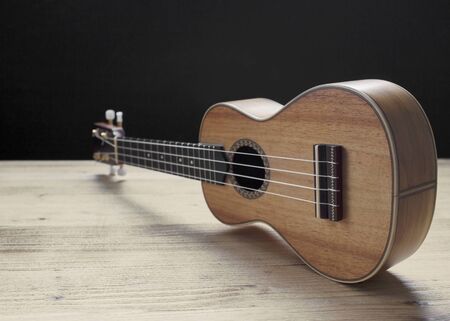 ukulele close up on wooden desk on black backgroundの写真素材