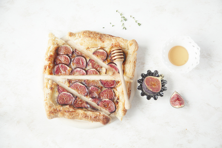 Fig tart with cheese, honey and thyme on white background. Minimal.の写真素材
