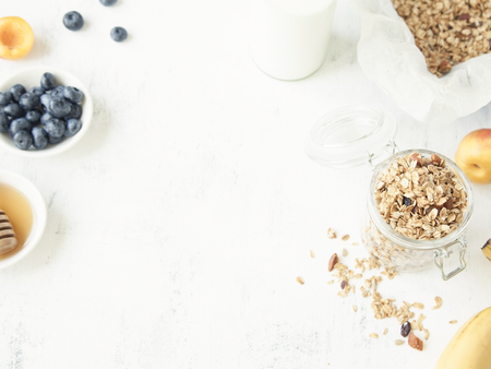 Granola in a jar with fruits and milk. Healthy breakfast concept.の写真素材