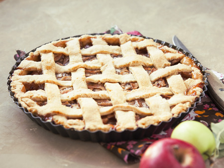 Traditional home-made apple pie on brown shabby background. Selective focus. Toned.の写真素材