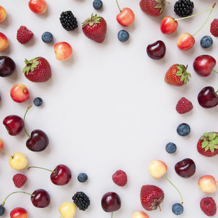Variety of fresh juicy berries (strawberry, cherry, raspberry, blueberry). Minimal food frame. Summer food.の写真素材