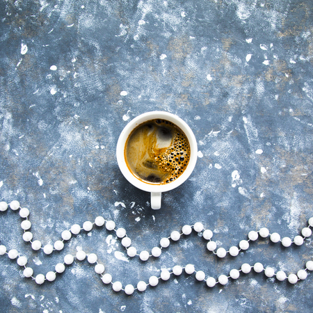 Cup of fresh hot black coffee on blue and white winter background shot from above. Copy space.の写真素材