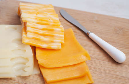 Slices of different kinds of cheese - swiss, cheddar, marble の写真素材