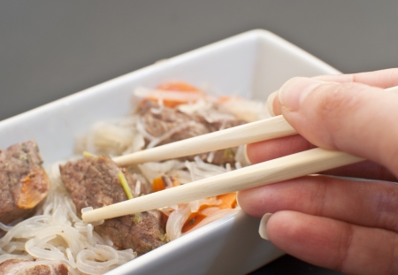 Eating asian meat with glass noodles の写真素材