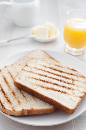plate with toasts, butter and juice  の写真素材