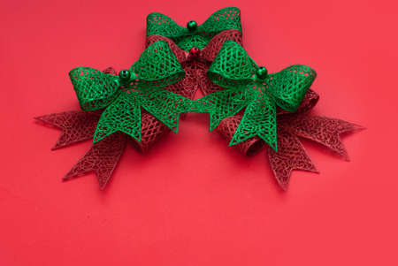 Christmas decoration bows red and green on red backgroundの写真素材
