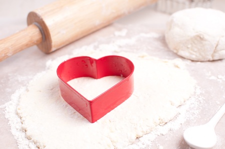 Red heart cookie cutter and dough rolling pinの写真素材