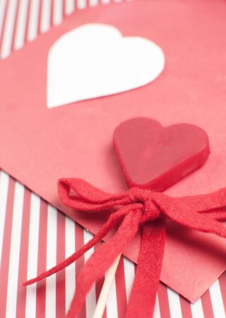 Heart shaped candy on striped red backgroundの写真素材