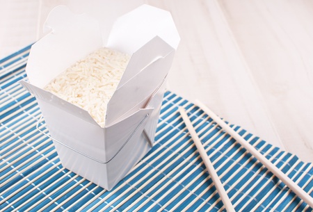 Box with cooked rice with chopsticksの写真素材