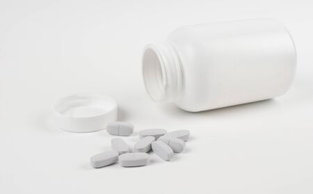 Medicine tablets spilled from bottle horizontalの写真素材