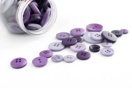 Purple buttons spilled from jar isolatedの写真素材
