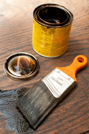 Paintbrush and open tin with dark paintの写真素材